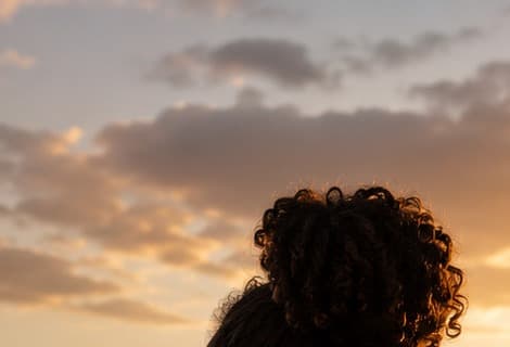 Sunset sky over hills, silhouette of a woman's hair