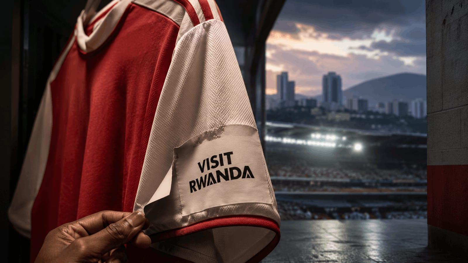 An Arsenal-style football shirt with a peeling “Visit Rwanda” sleeve patch inside a stadium tunnel, symbolising the end of Rwanda’s long-running sponsorship partnership with Arsenal